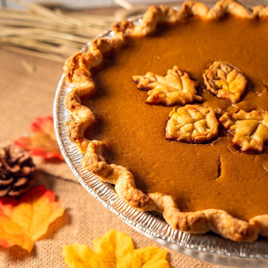 Rustic pumpkin pie with decorative leaf-shaped crust cutouts.