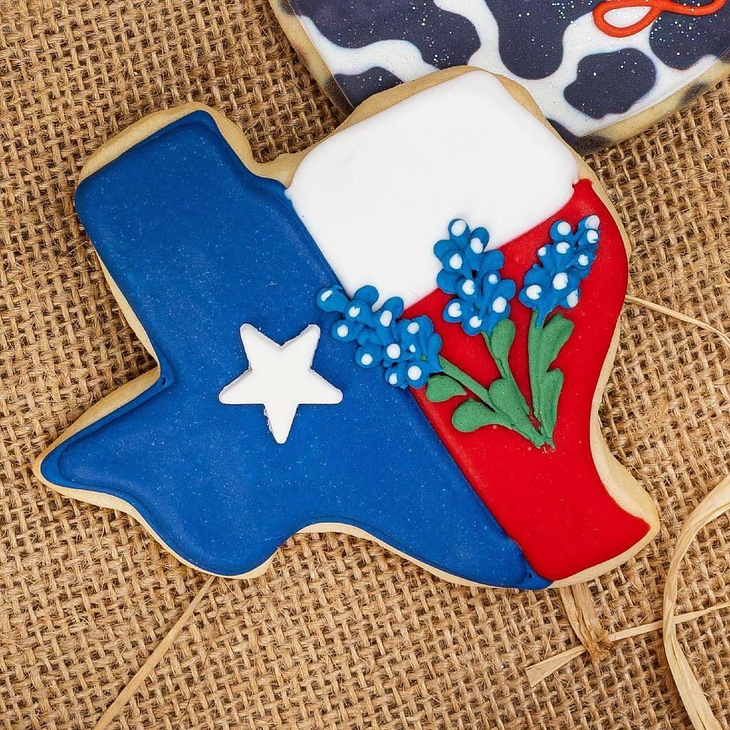 Texas-shaped cookie with bluebonnet and flag icing design