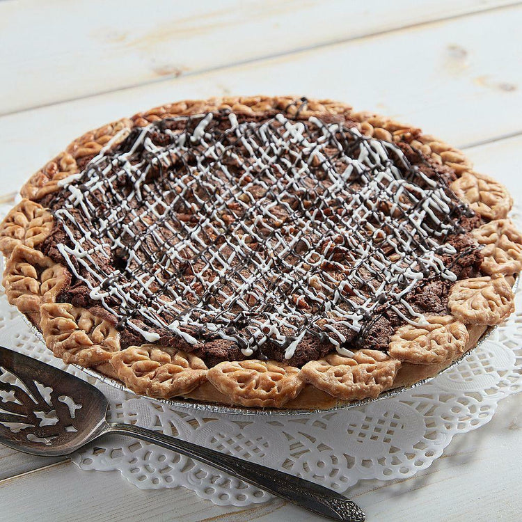 Fudge pecan pie with decorative leaf crust and icing drizzle.