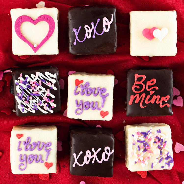 Valentine Petit Fours with chocolate and icing on red fabric.