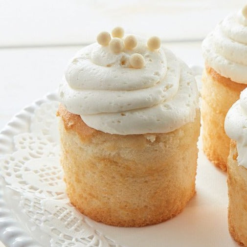 Assorted cupcakes with white frosting and pearl sprinkles.