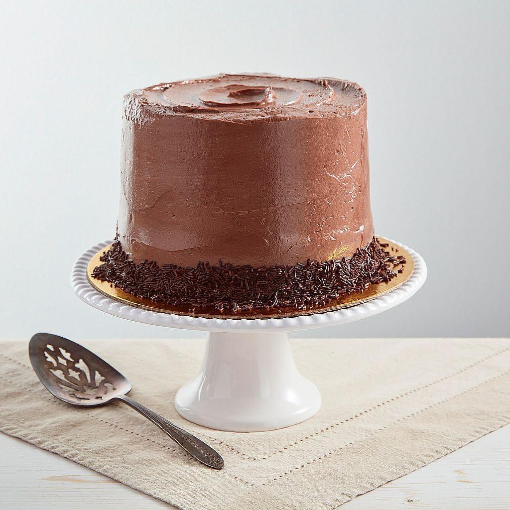6-inch vegan chocolate cake with sprinkles on a white stand