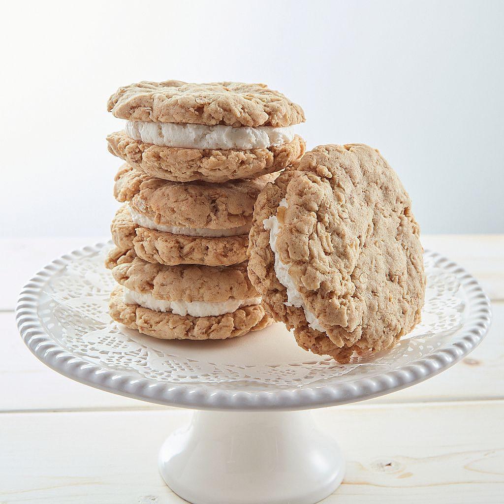 Vegan oatmeal whoopie pies stacked on a white pedestal stand.