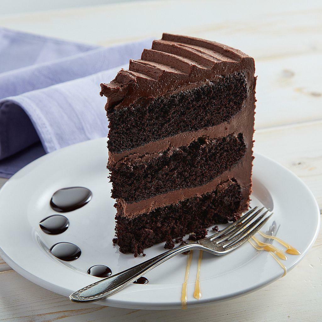 Slice of 9-inch vegan chocolate cake with frosting layers.