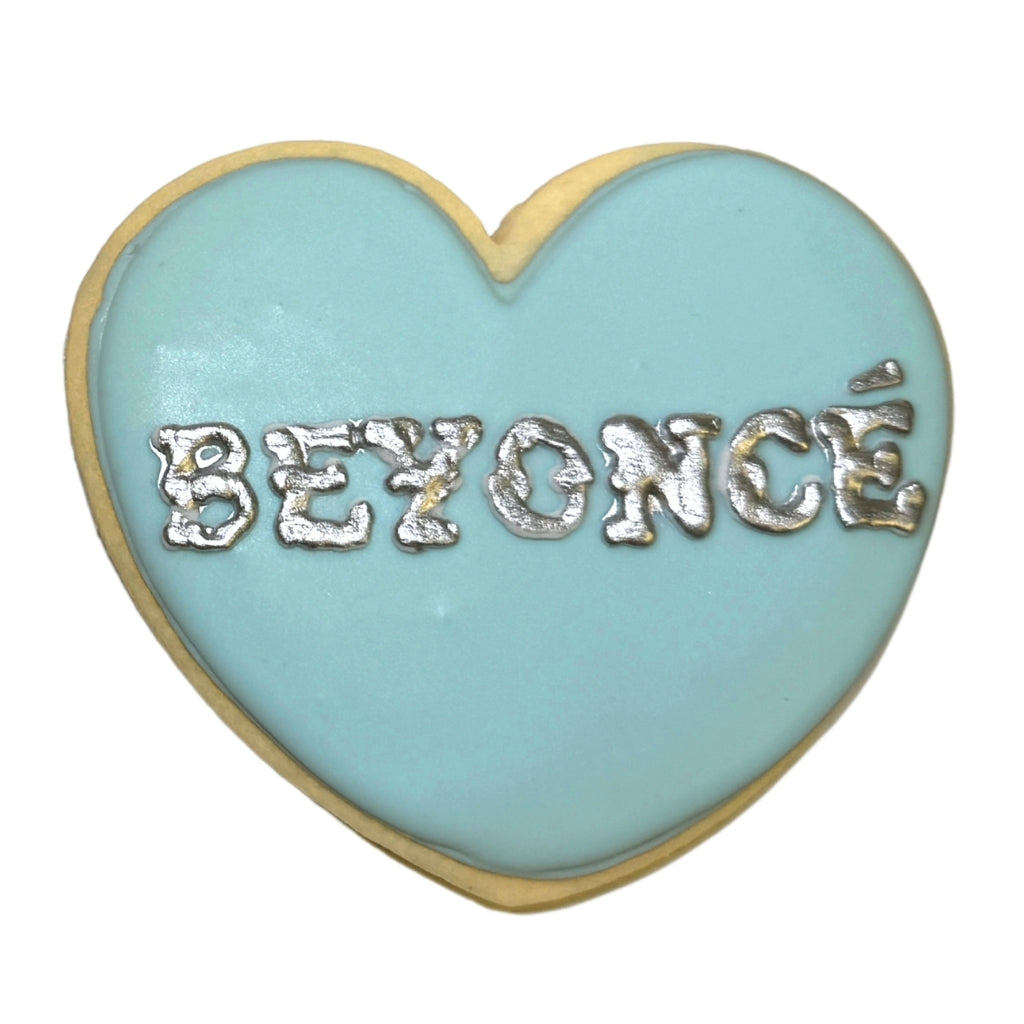 Beyoncé heart cookie with light blue icing and silver lettering.