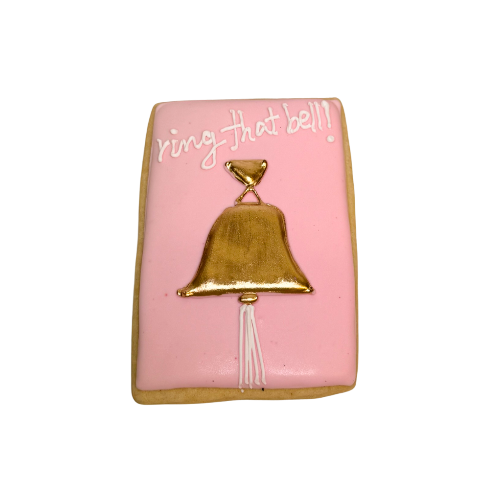 Breast Cancer Awareness cookie with gold bell and icing.