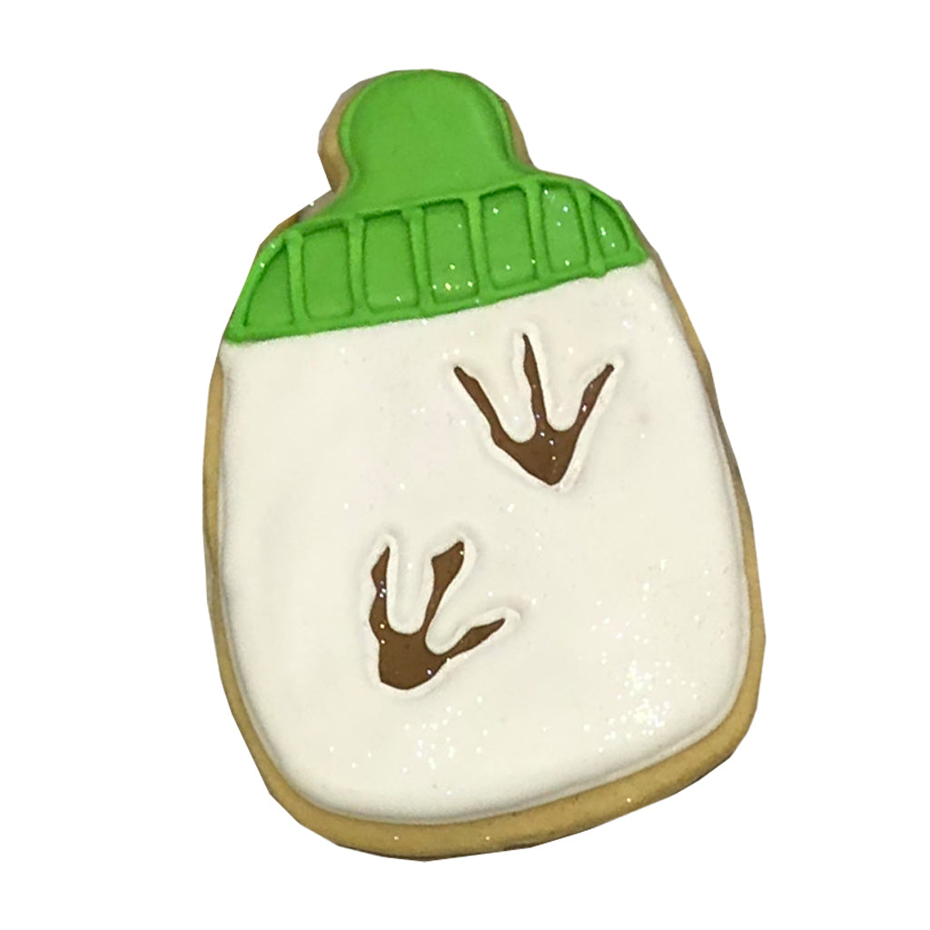 Dino bottle cookie with green cap and brown dinosaur tracks.