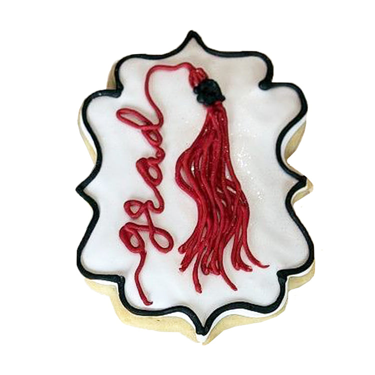 Graduation tassel cookie with red icing on white background