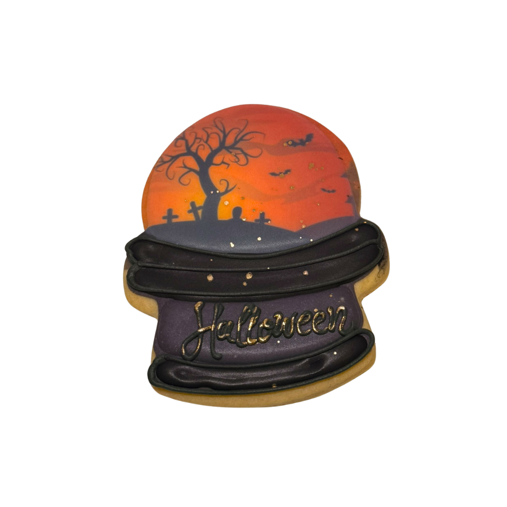 Halloween cookie shaped like a crystal ball with a spooky scene.