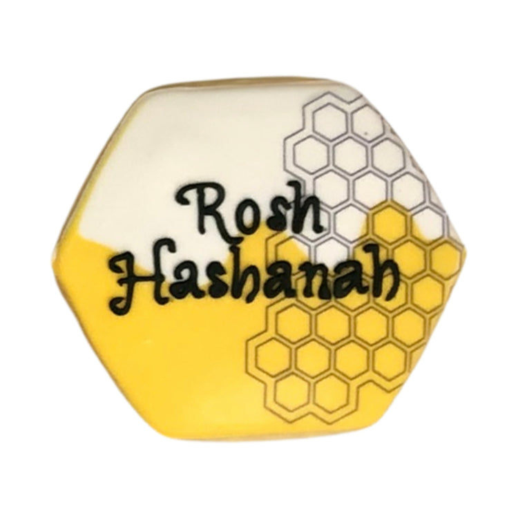 Hexagonal Rosh Hashanah cookie with yellow honeycomb design.