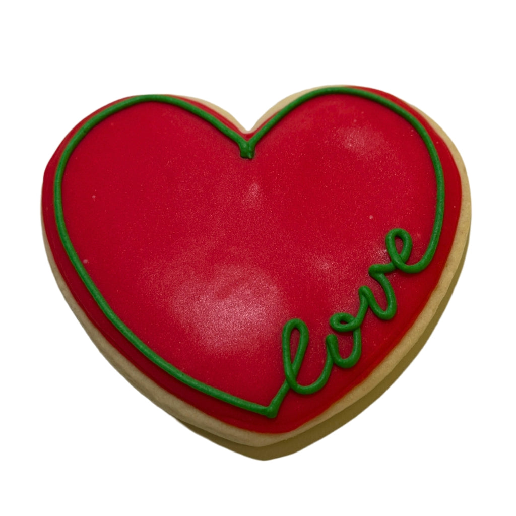Heart-shaped Juneteenth cookie with red icing and green love text.