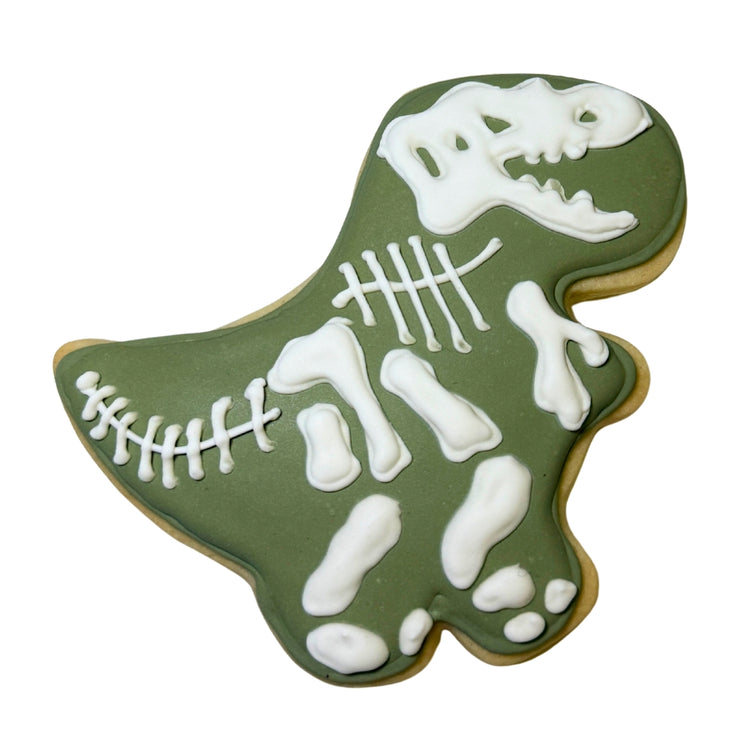 Jurassic Cookie shaped like a T-Rex with white icing skeleton.