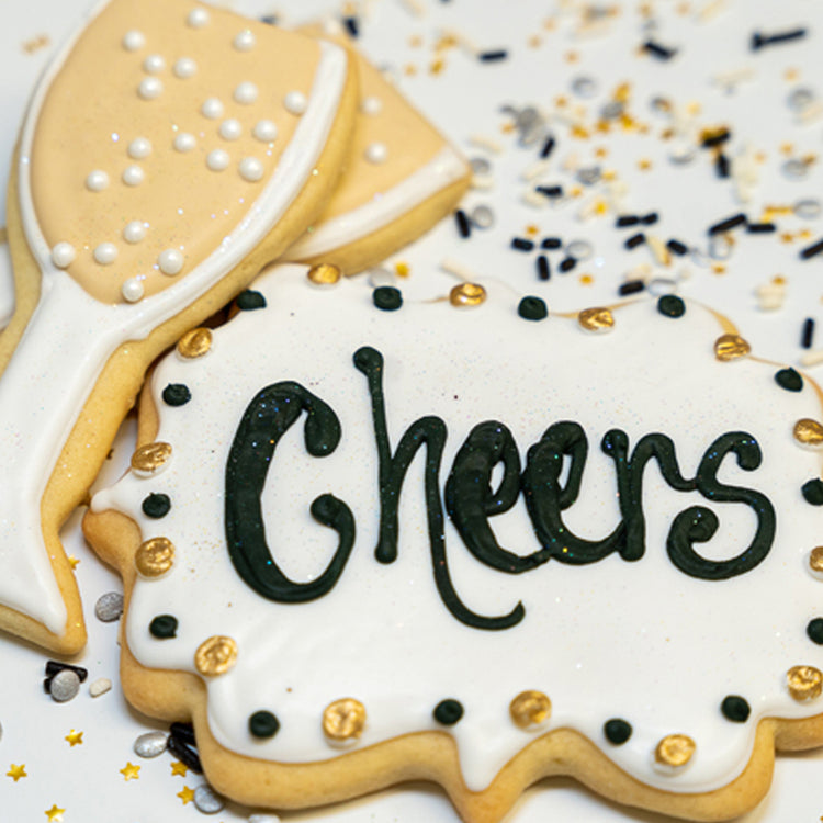 New Year butter cookies shaped like champagne flutes and Cheers sign