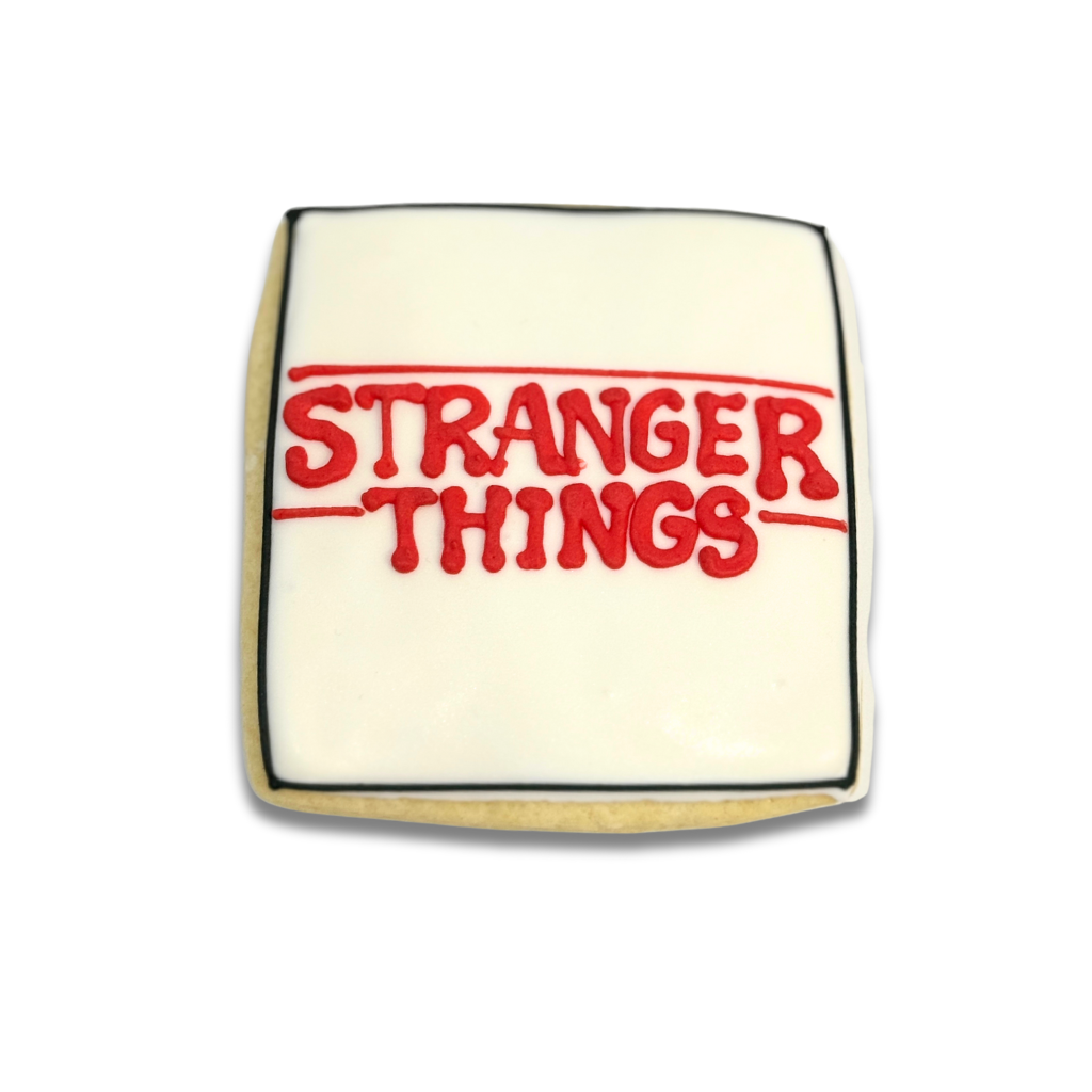 Stranger Things cookie with white icing and red lettering.