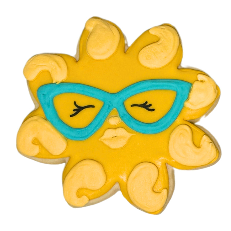 Summer cookie shaped like a yellow sun wearing blue glasses.