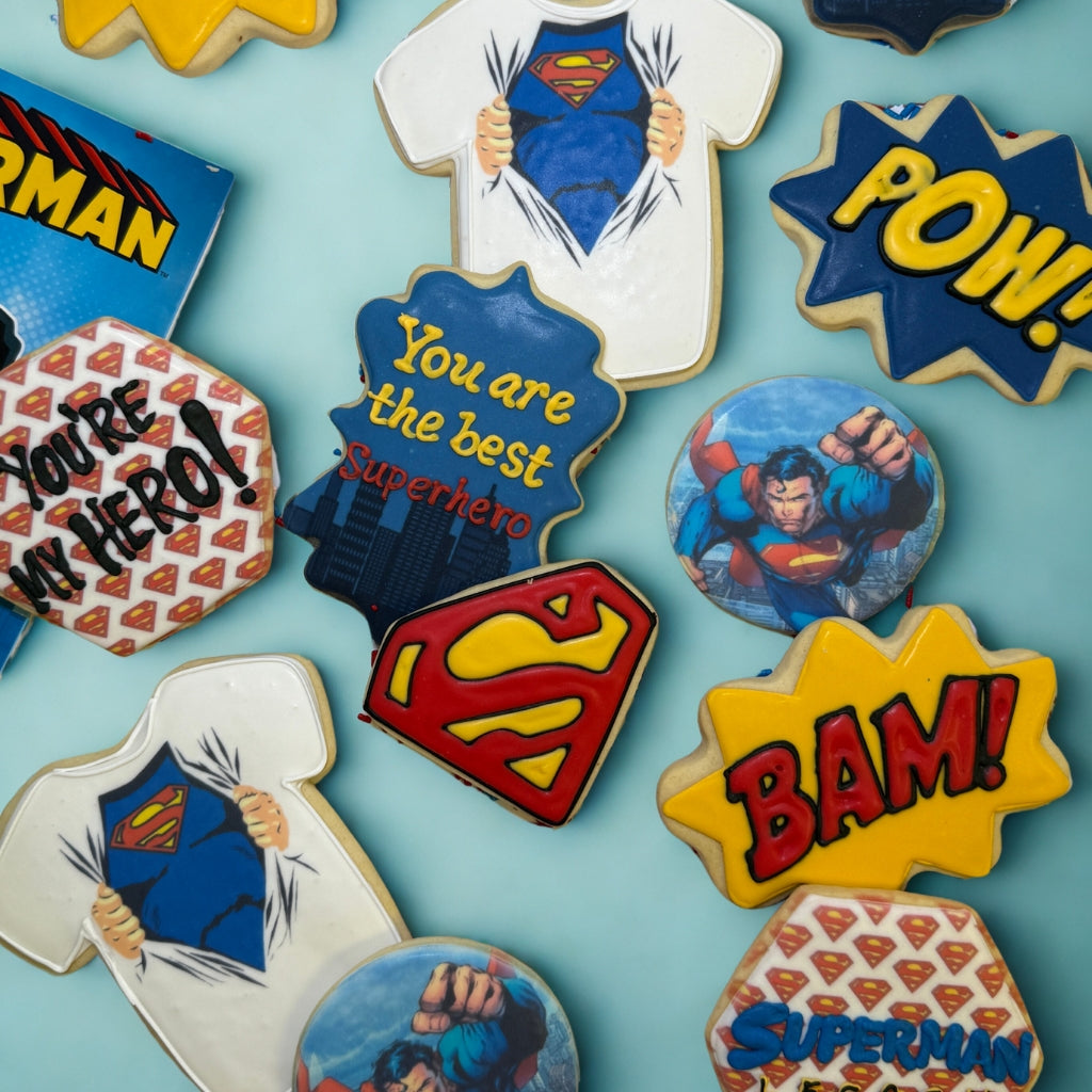 Assorted Superman themed sugar cookies with colorful icing.