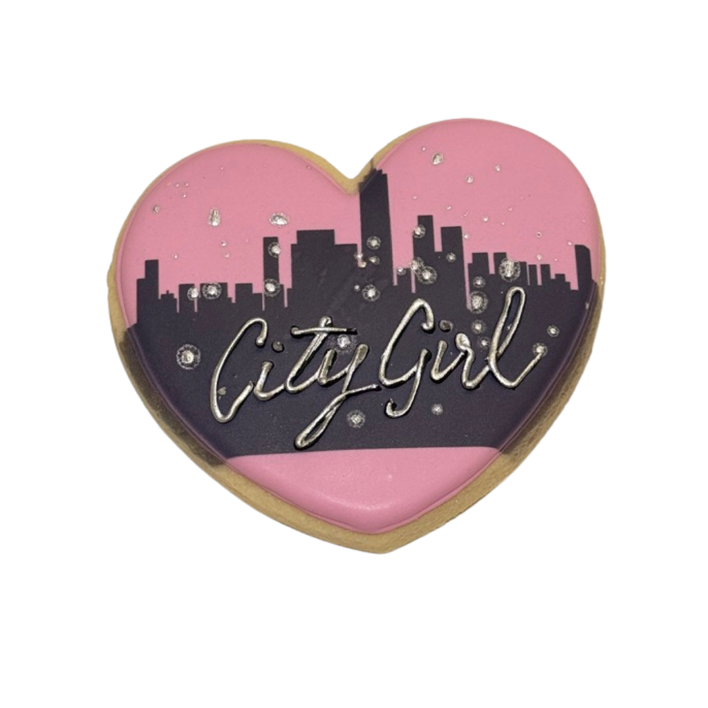 Heart-shaped cookie with pink and black city skyline design.