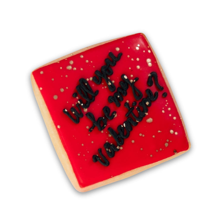 Square Valentine butter cookie with red icing and gold speckles.
