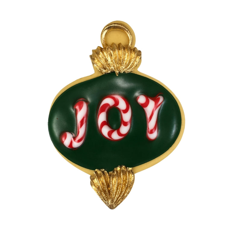 Ornament cookie with green icing and candy cane JOY lettering.