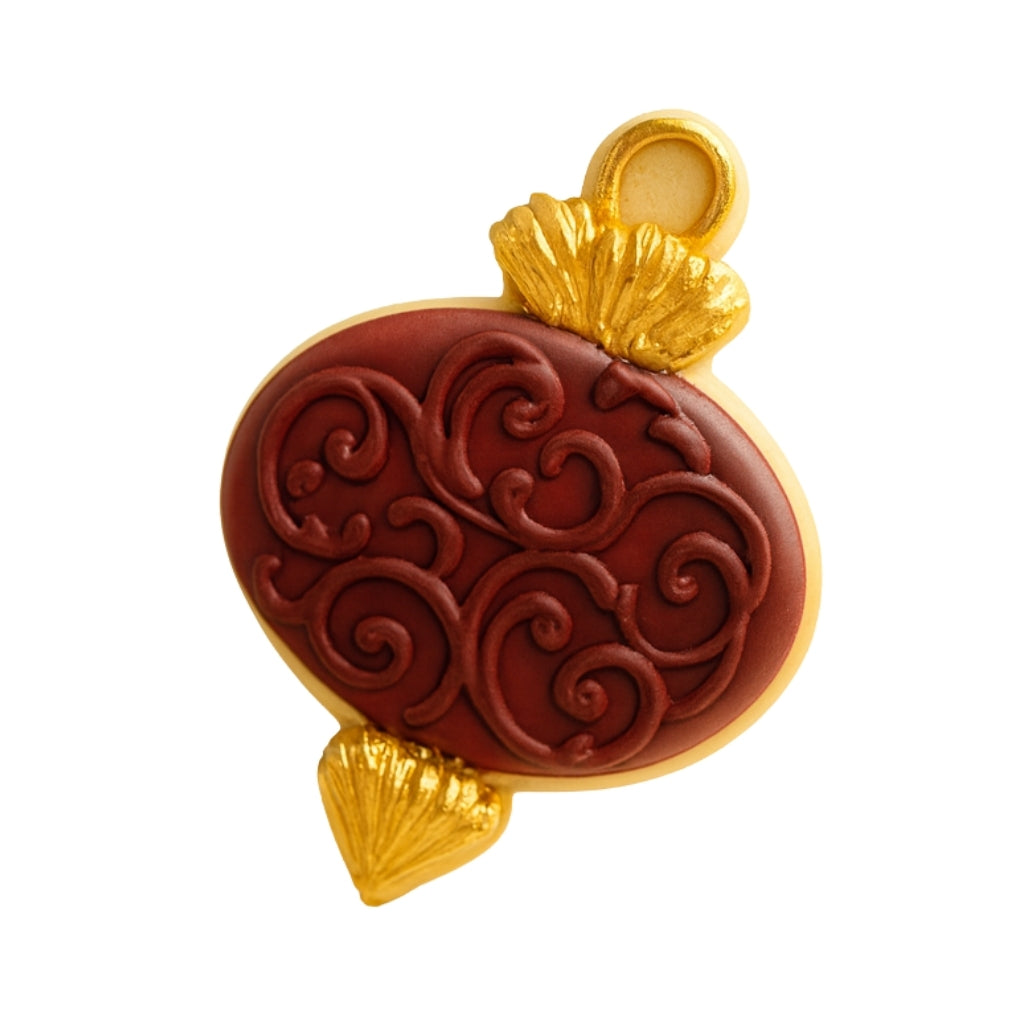 Ornament cookie with deep red icing and gold accents