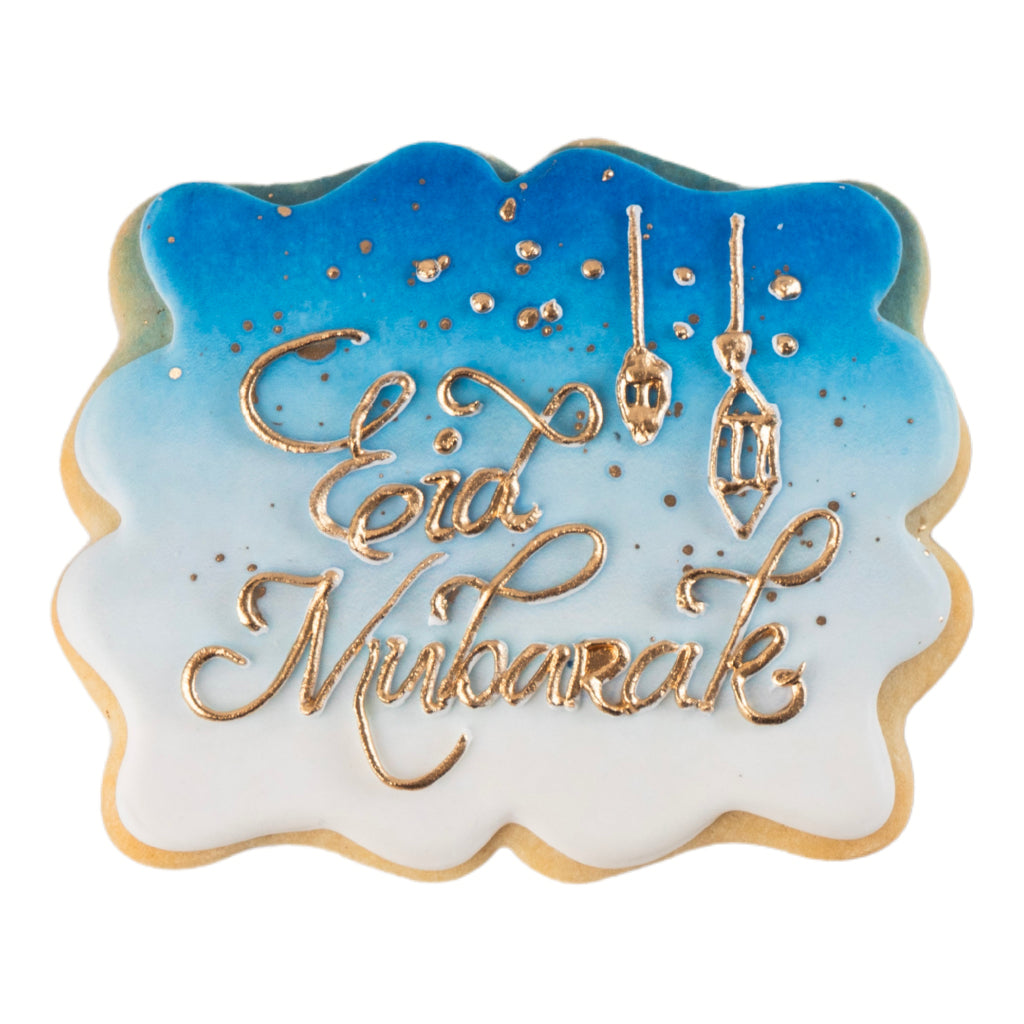 Eid Mubarak butter cookie with blue ombre icing and gold script.