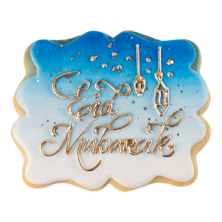 Eid Mubarak butter cookie with blue ombre icing and gold script.