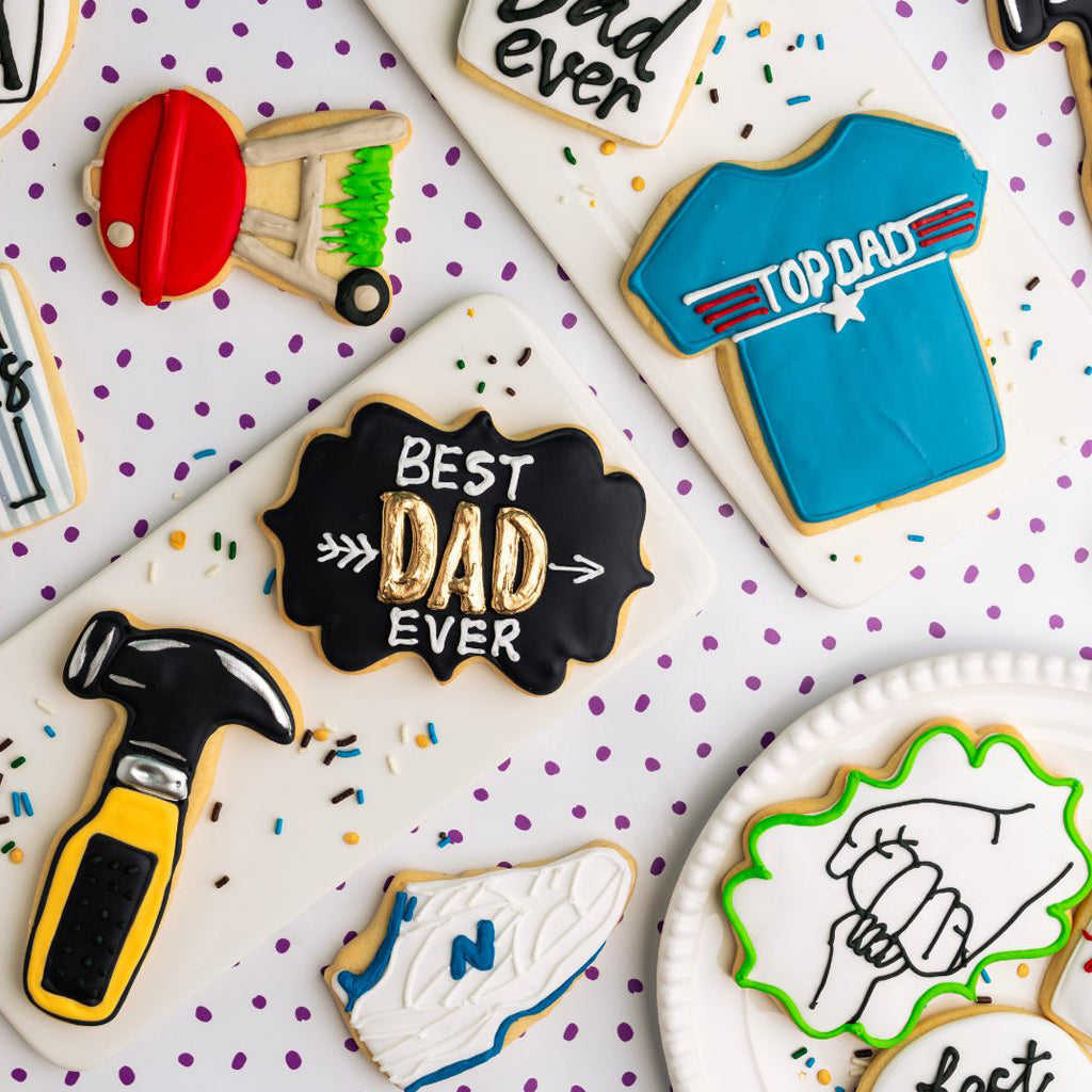 Assorted Father's Day cookies with icing on white platters.