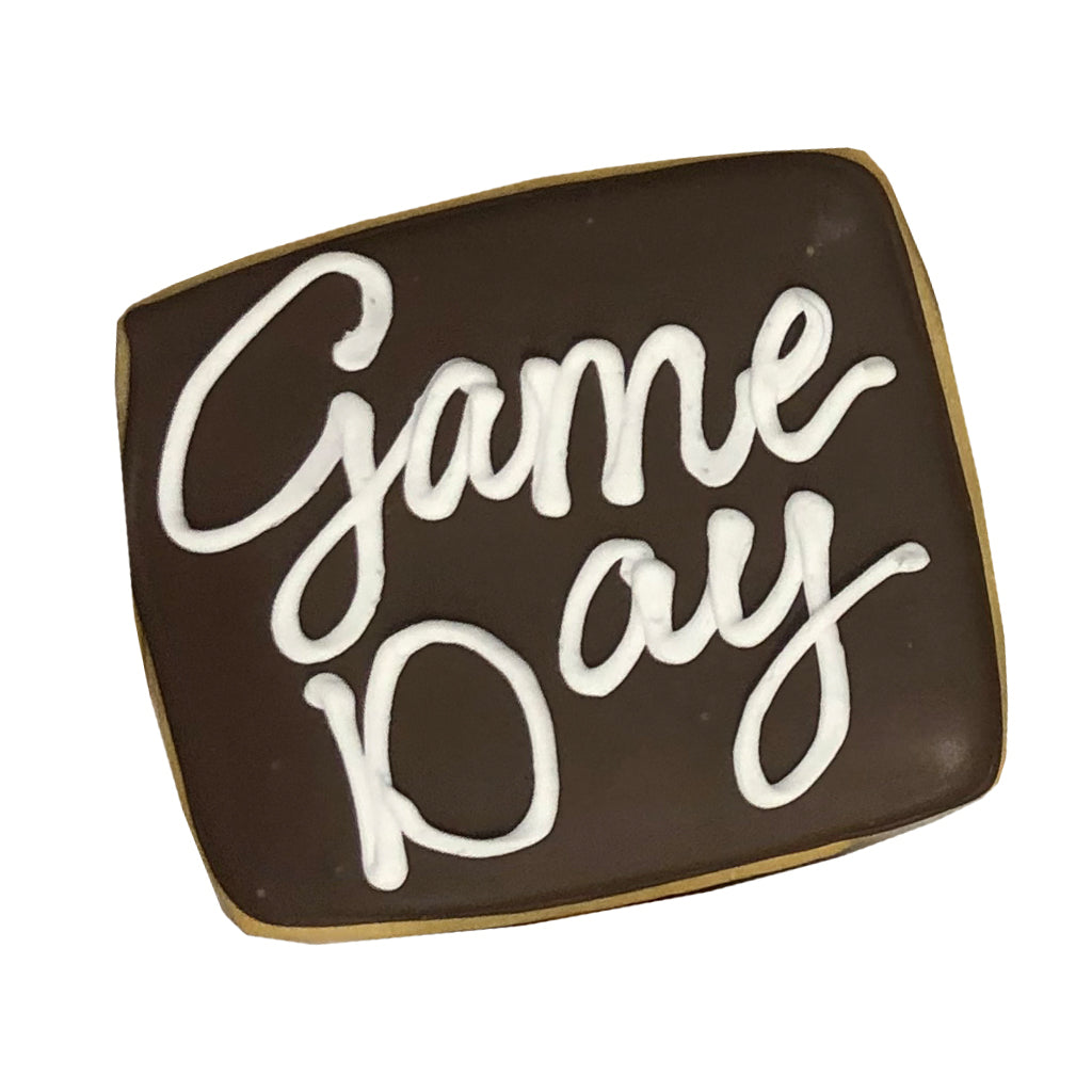 Square Game Day plaque cookie with dark icing and white script.