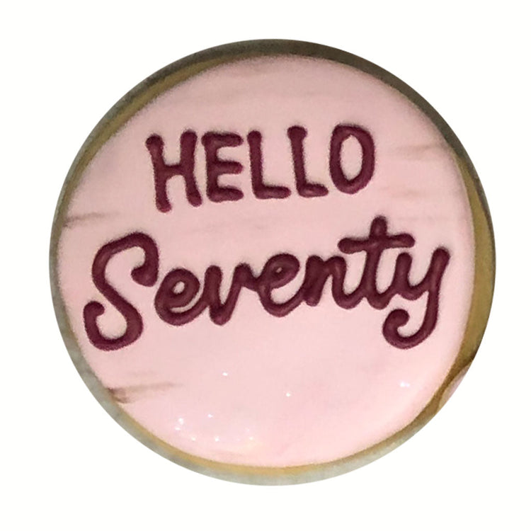 Hello 70 circle cookie with pink icing and maroon text.