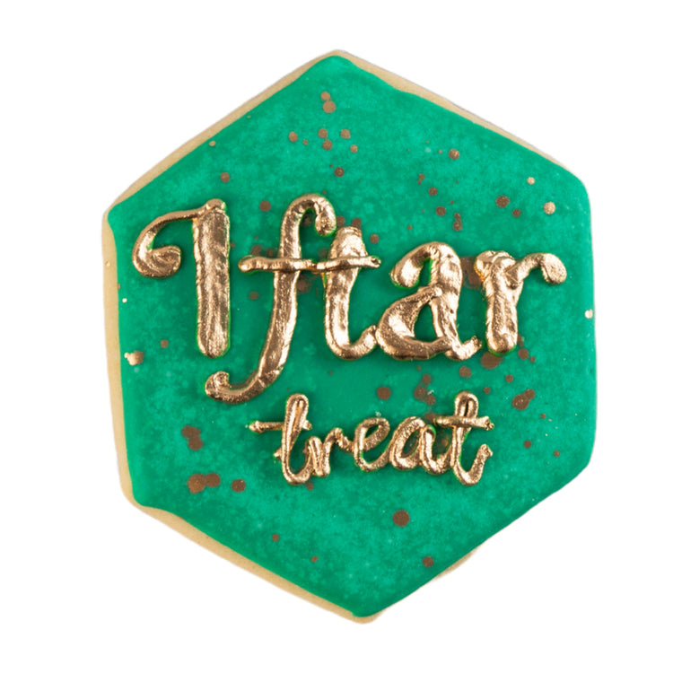 Hexagonal Ramadan butter cookie with green icing and gold text.