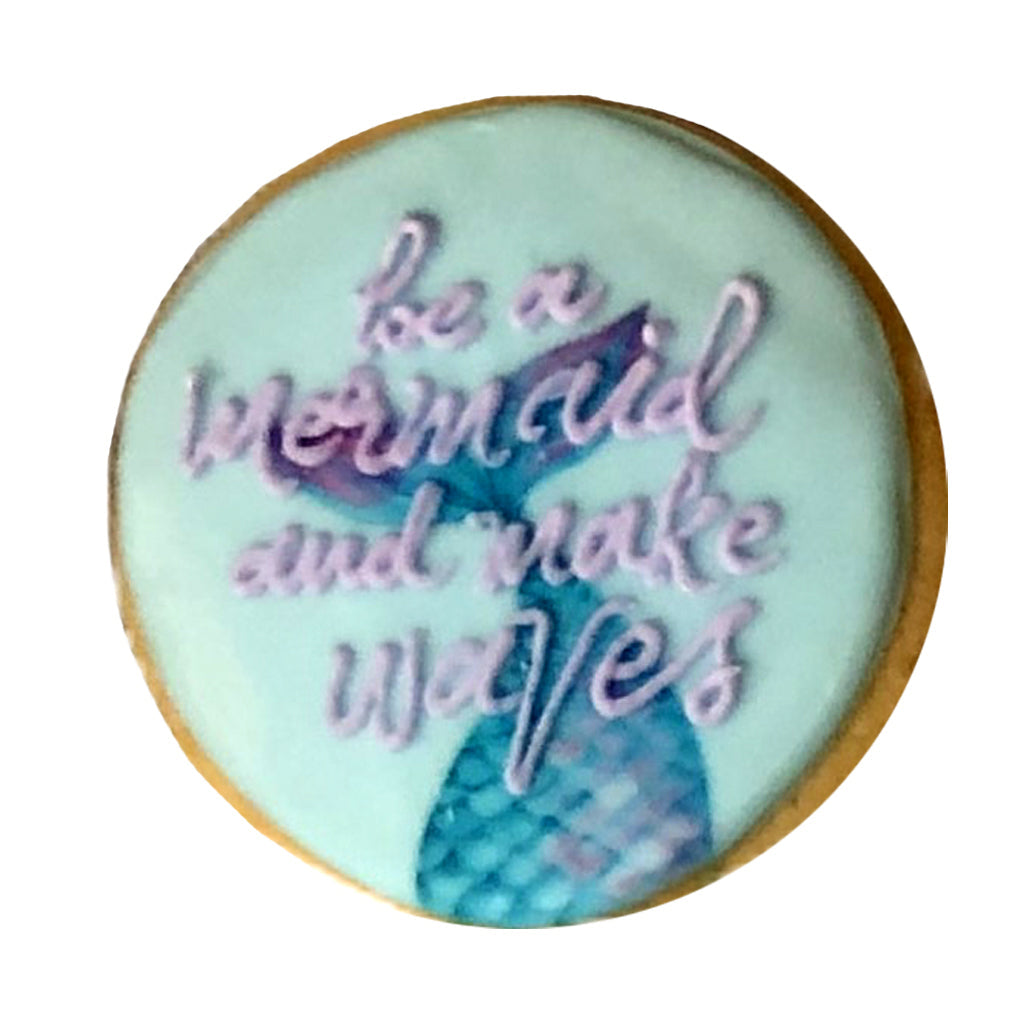 Little Mermaid cookie with teal icing and purple lettering.