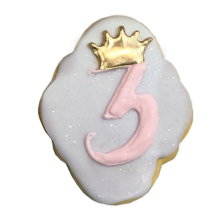 Princess 3 cookie with pink icing and a gold crown topper.