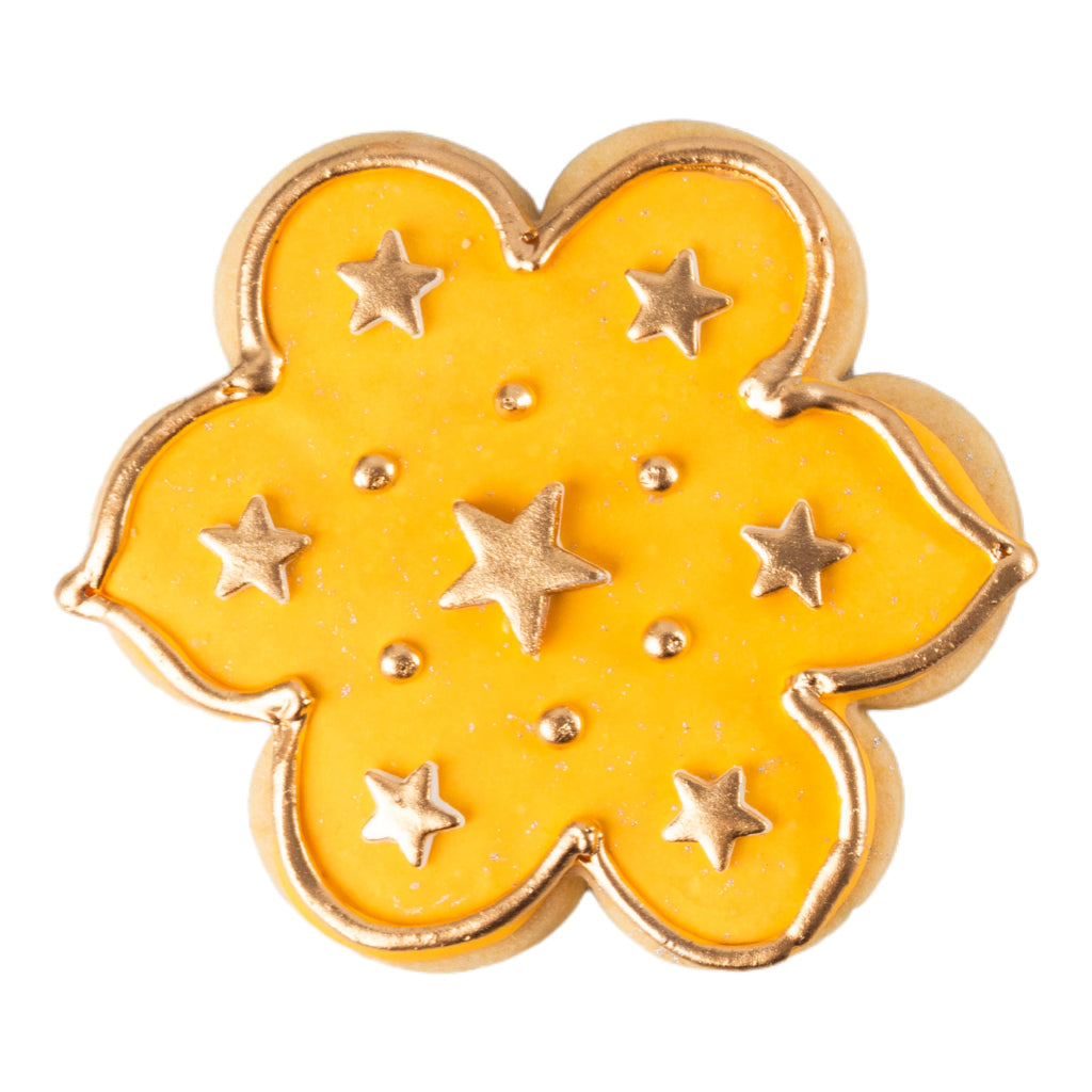 Flower-shaped Ramadan butter cookie with gold star icing.
