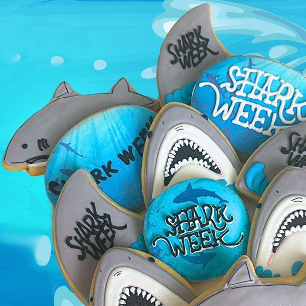 Assorted Shark Week cookies with shark and logo designs.