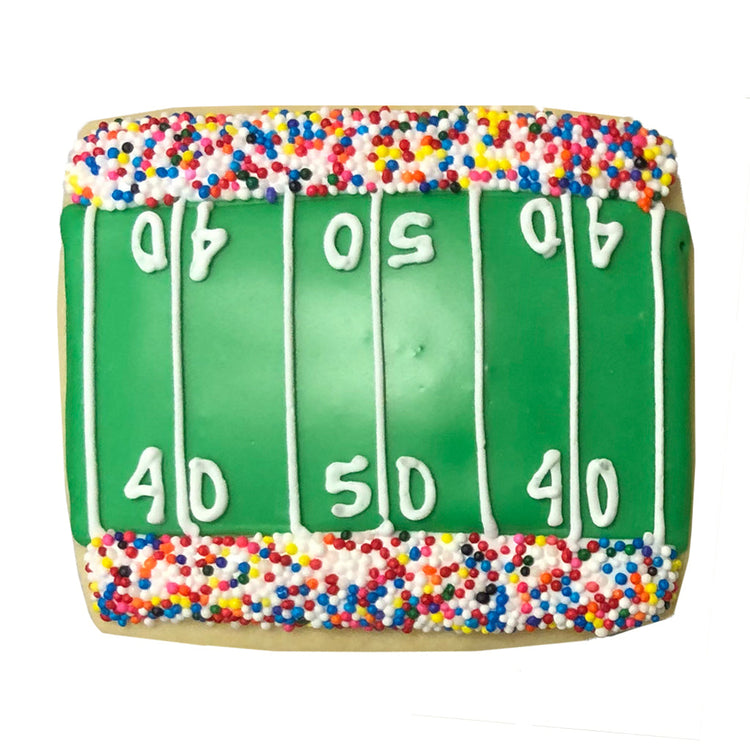 Football stadium cookie with green icing and rainbow sprinkles.