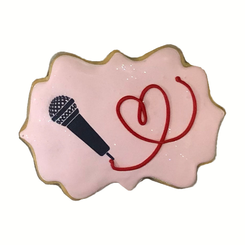 Taylor Swift microphone cookie with pink icing and red heart.