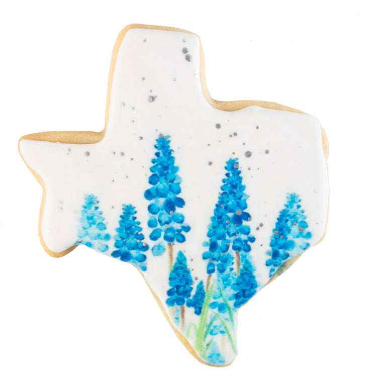 Texas-shaped cookie with bluebonnet floral icing design.
