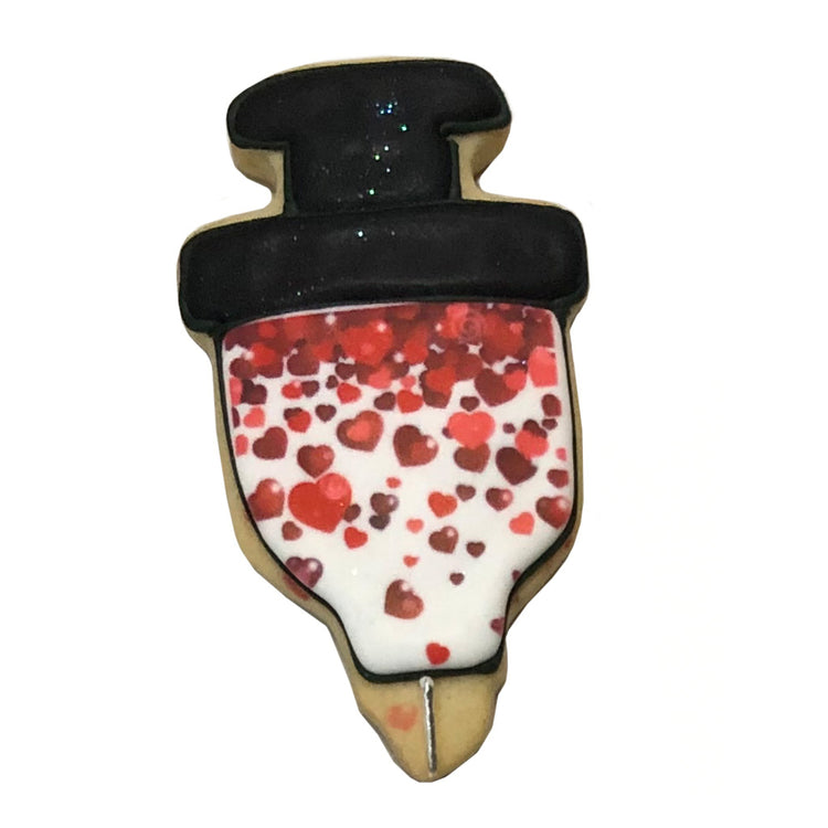 Syringe-shaped cookie decorated with red hearts and black icing