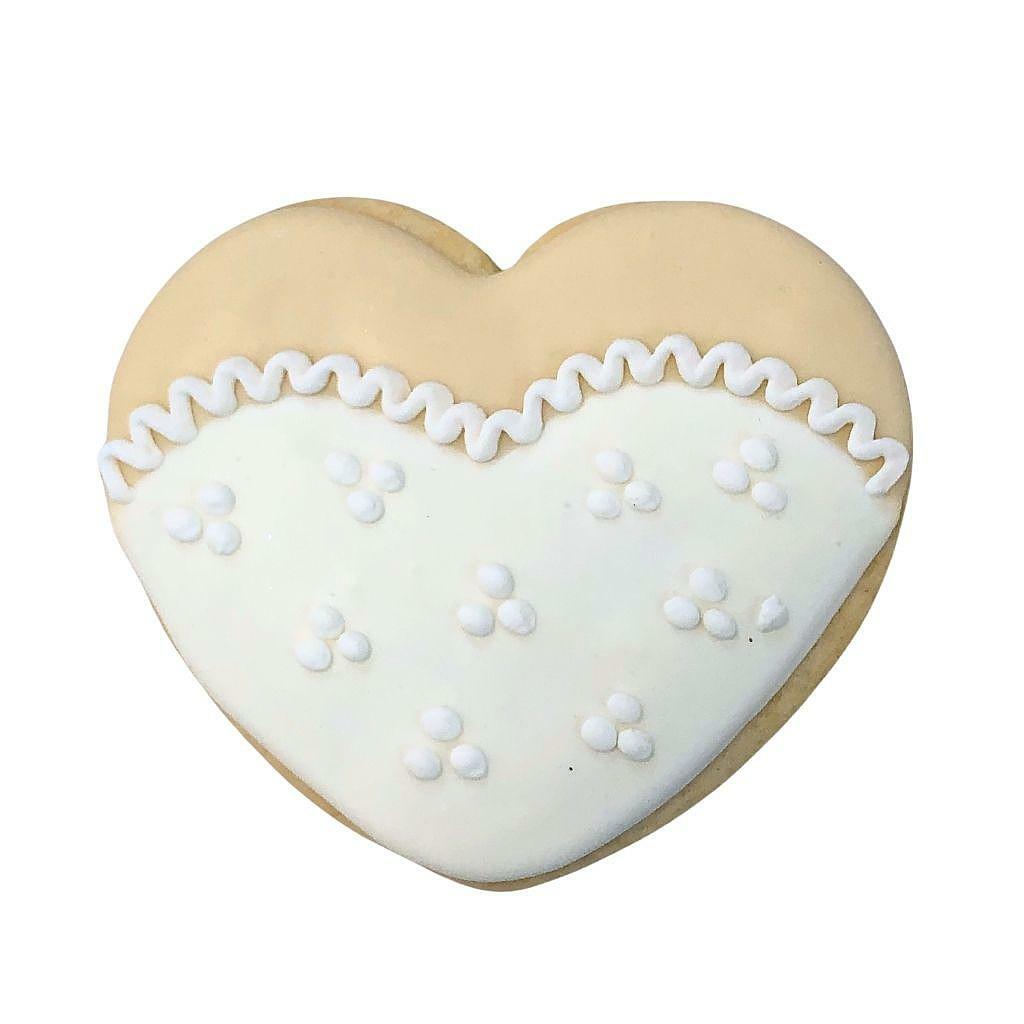 Heart-shaped cookie with white icing and lace detail.