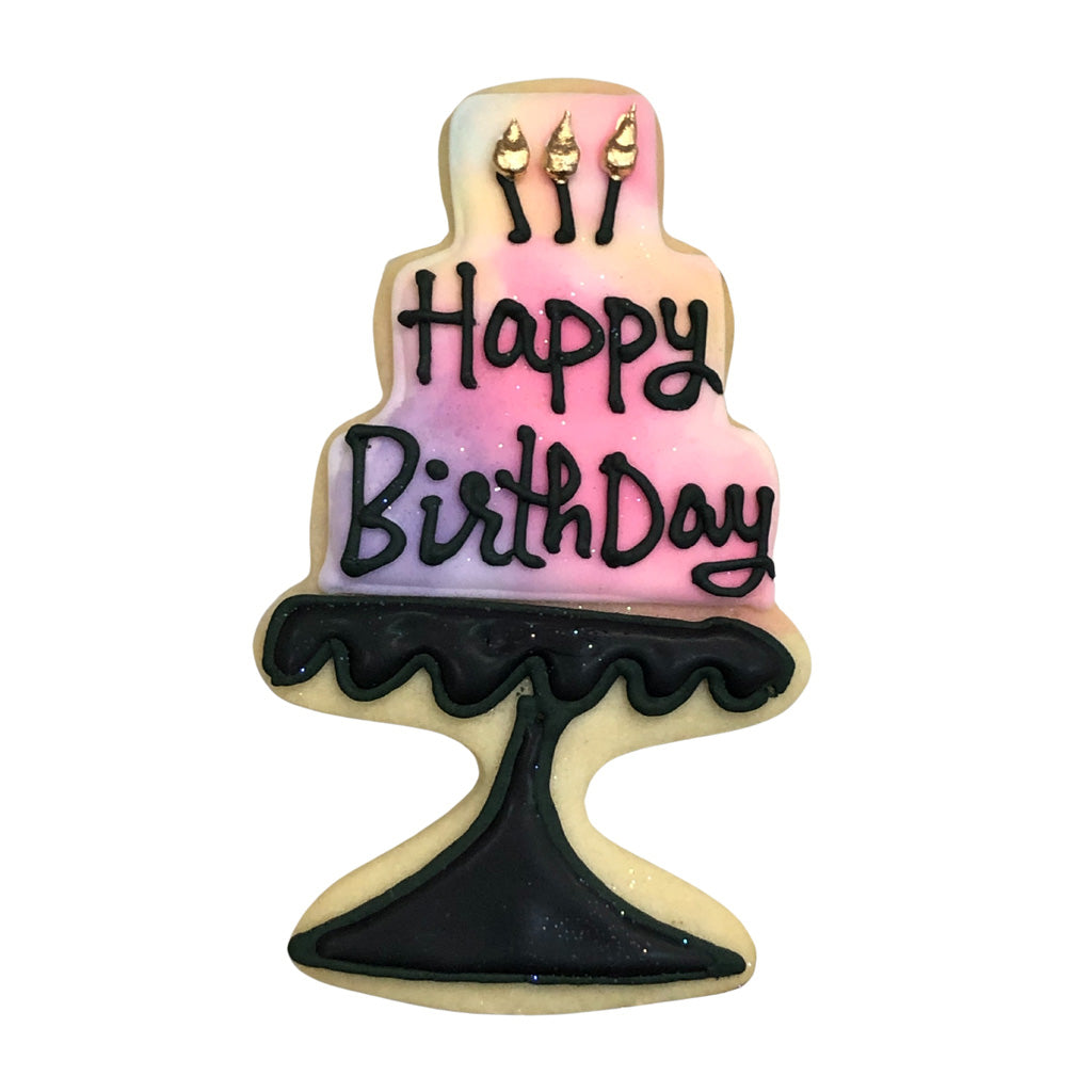 Birthday cake cookie on a black stand with pink icing.