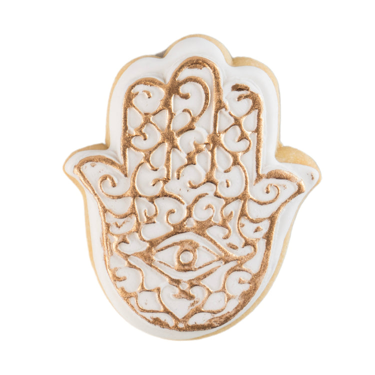 Hamsa-shaped butter cookie with white and gold icing