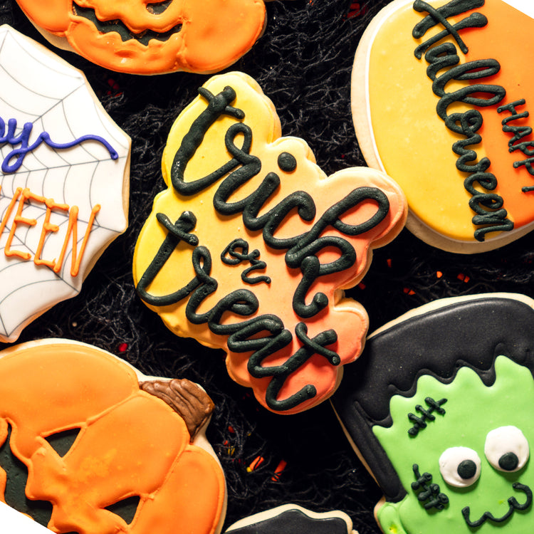 Assorted Halloween cookies with festive icing on black netting.