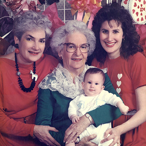 Four generations of women posing for a family portrait.