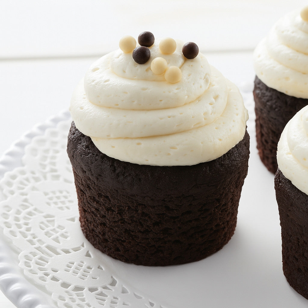 Assorted chocolate cupcakes with white frosting and pearls.