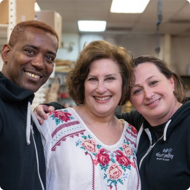Three smiling bakery staff members posing together.